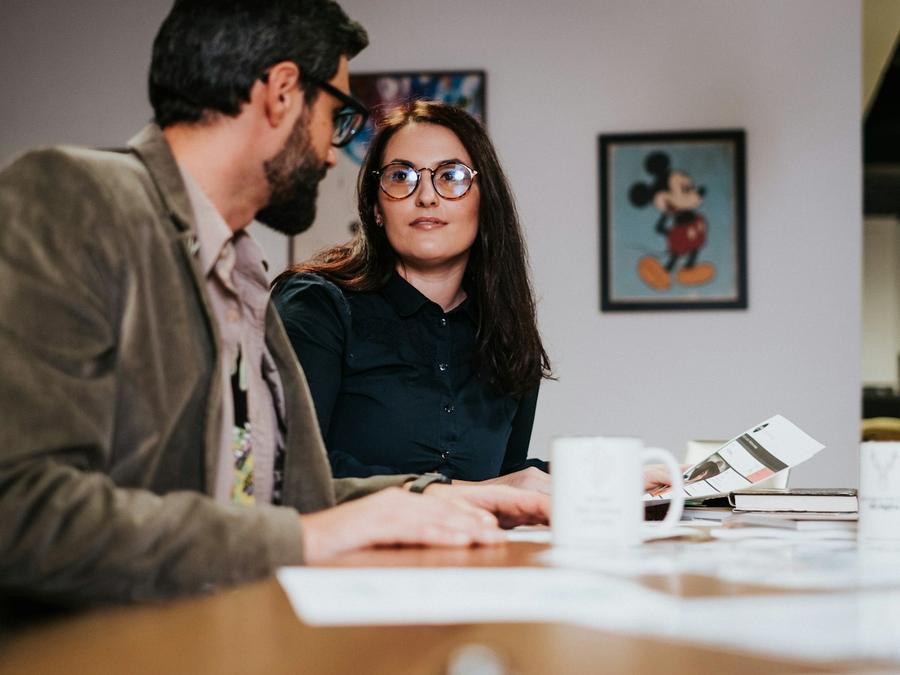Dos personas conversan en una reunión de trabajo